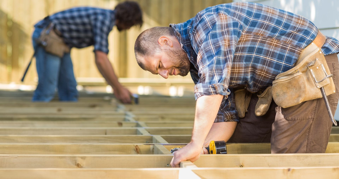 Carpenter working on wooden deck framing